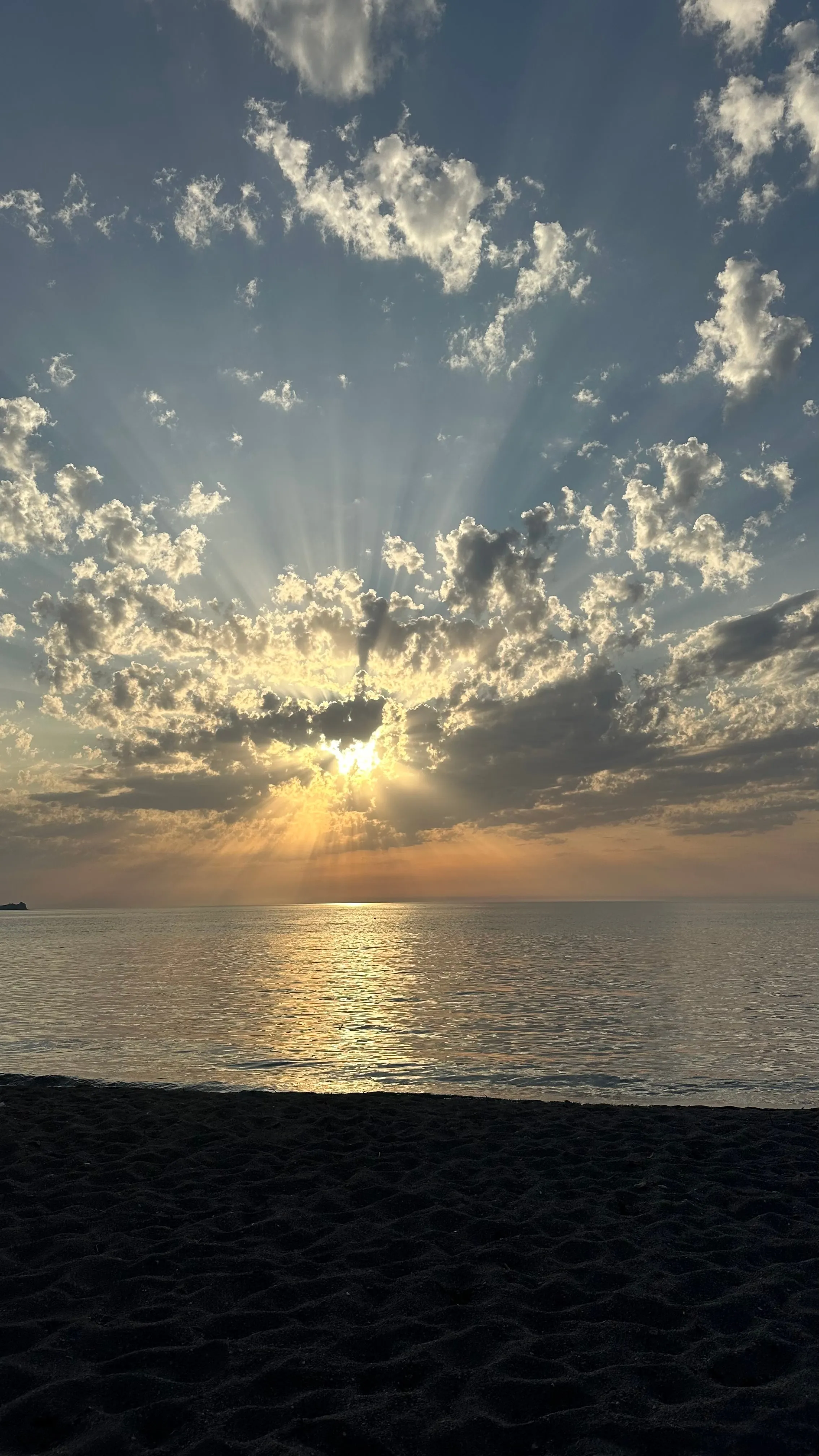 Sun breaking through clouds over the sea