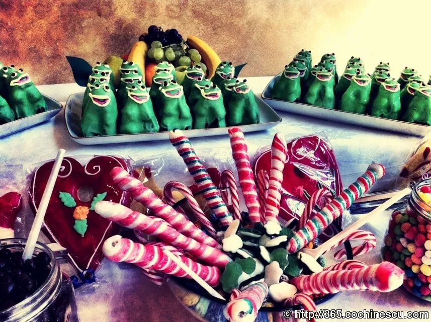 The table is full of colorful lollipops, gingerbread and green marzipan figurines.