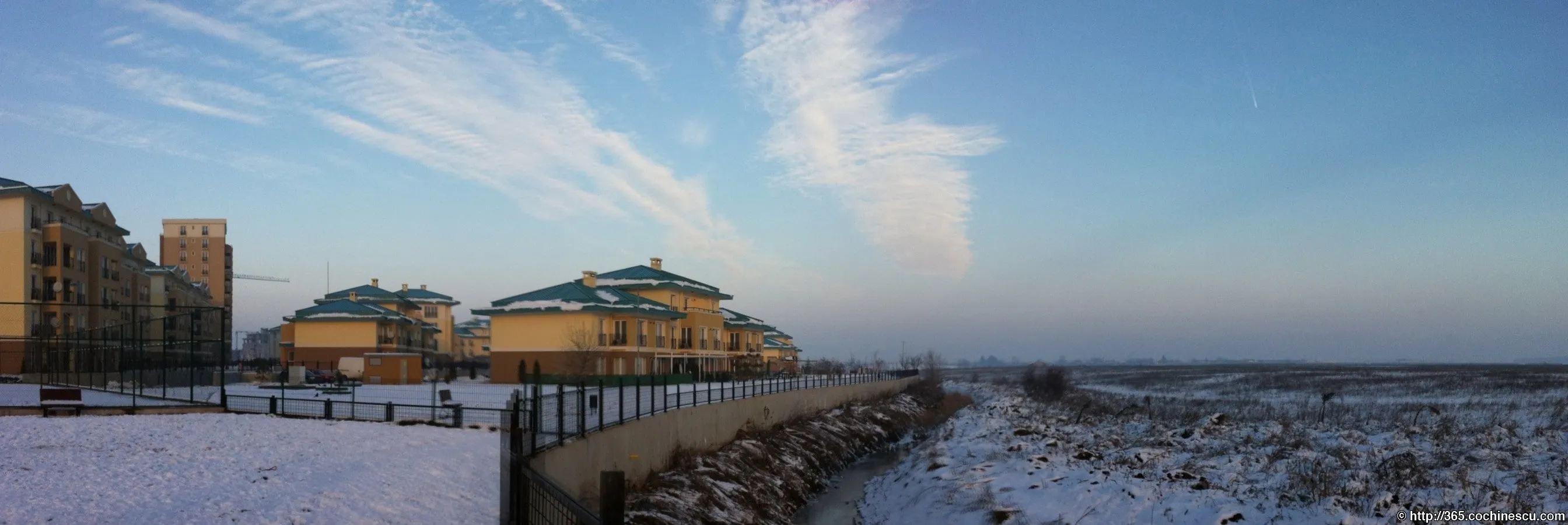 The houses in Cosmopolis and the nearby field are covered in snow.