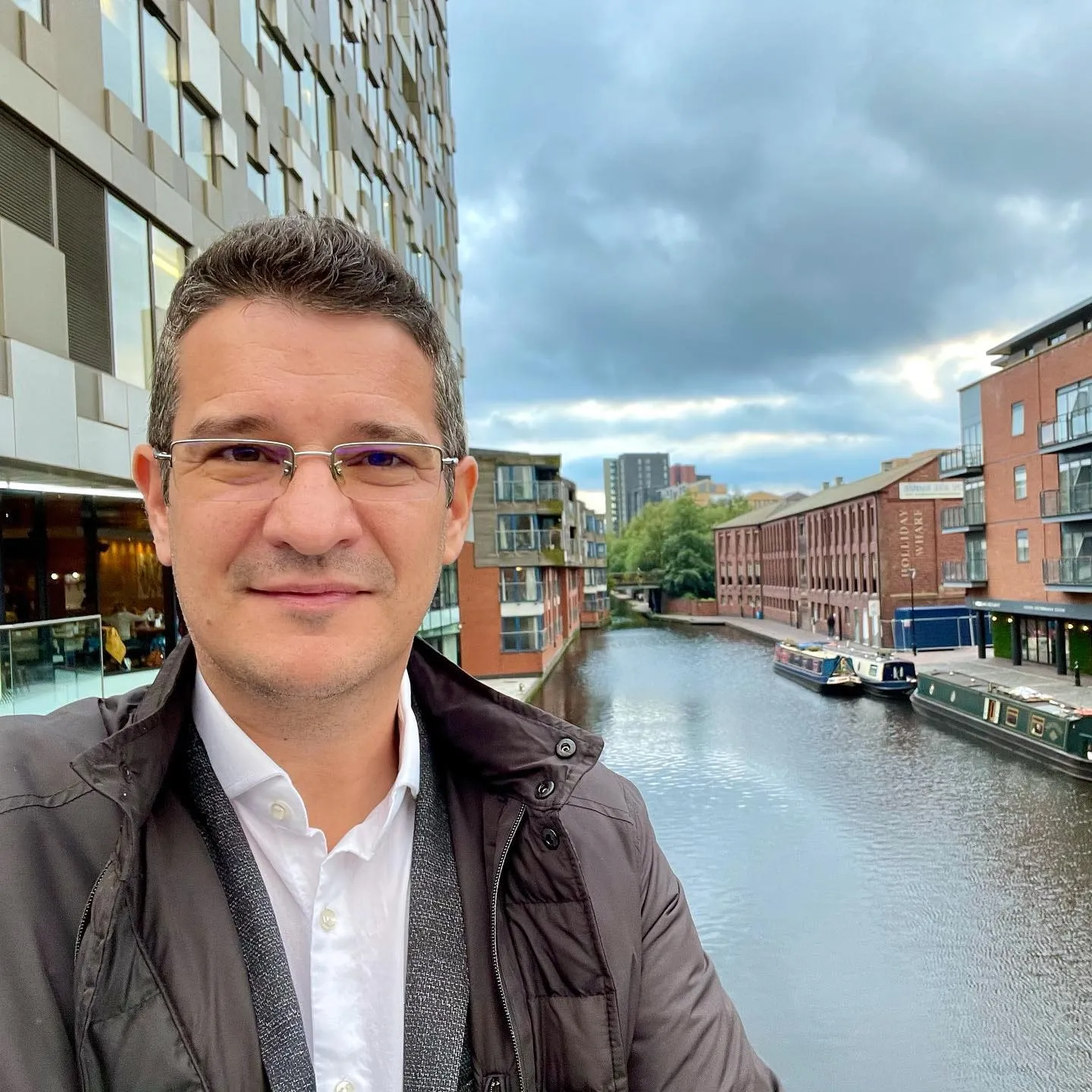 Sebastian Cochinescu takes a selfie beside a Birmingham canal lined with brick buildings and narrowboats.