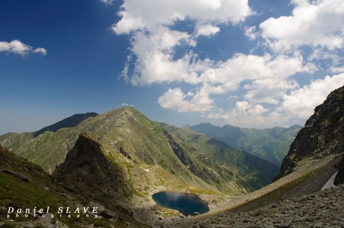 A glacial lake is seen in a rocky valley in the Făgăraș Mountains.