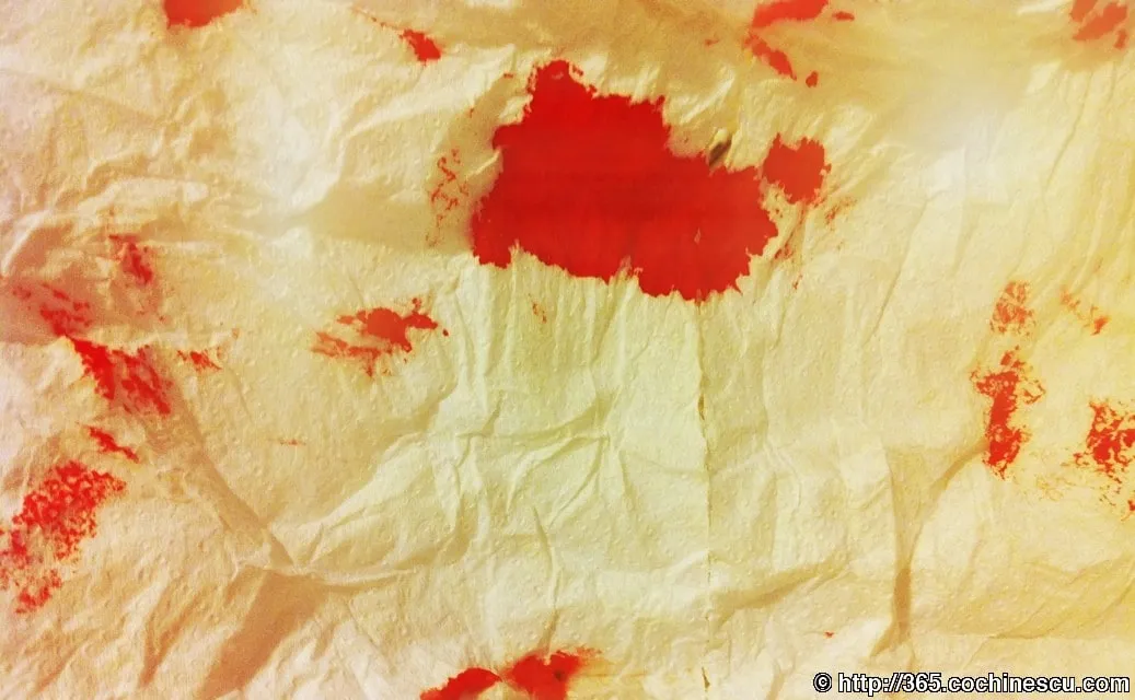 Irregular red stains on a white, crumpled surface.