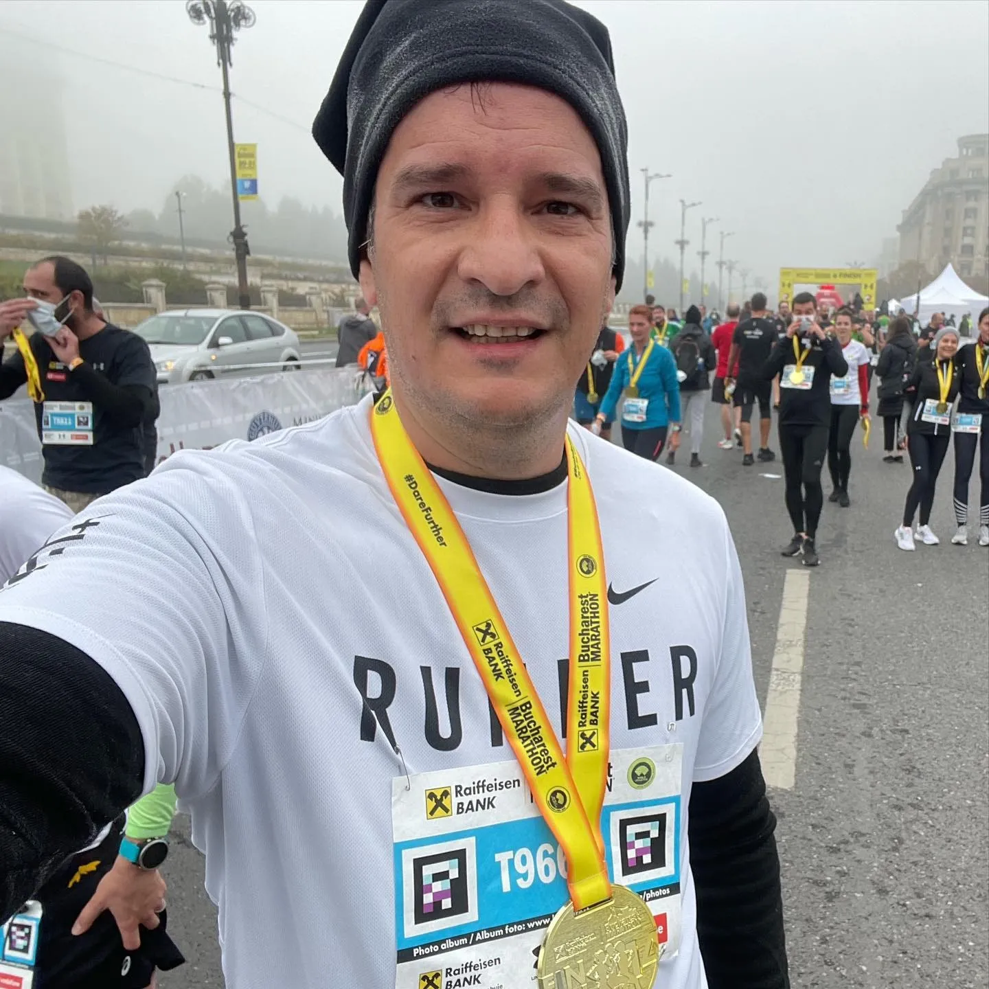 Sebastian Cochinescu takes a selfie wearing his finisher medal at the foggy Bucharest Marathon.