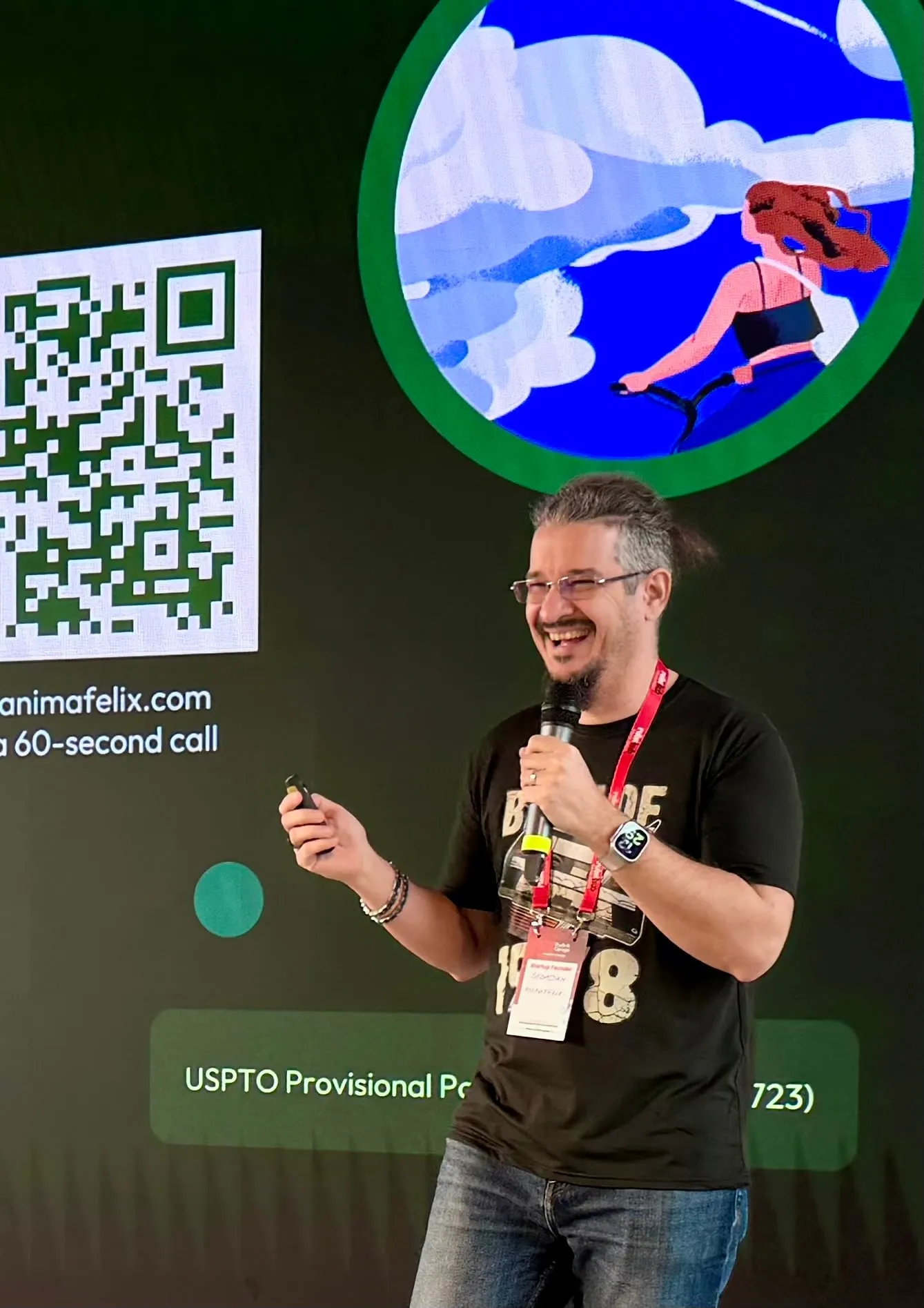 Sebastian Cochinescu speaking on stage with a microphone next to a QR code slide