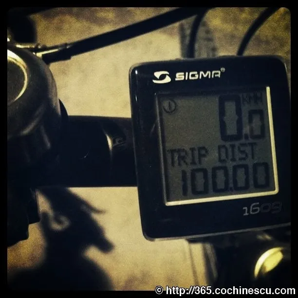 A bicycle computer showing a distance of 100 kilometers traveled.