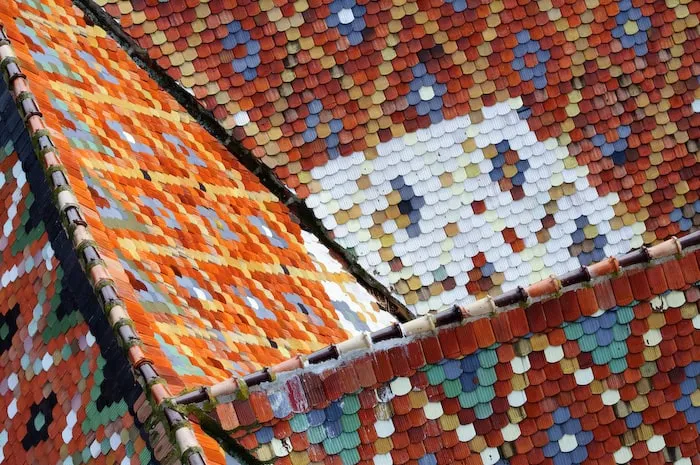 A roof is covered with multicolored glazed tiles arranged in geometric patterns.