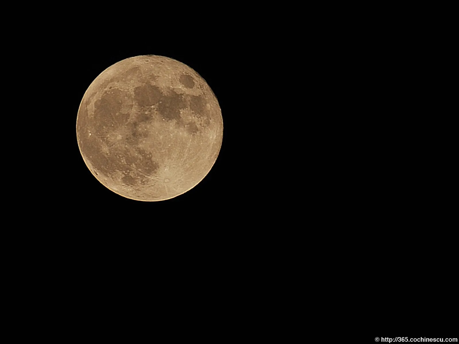 The full moon is photographed against the black sky.