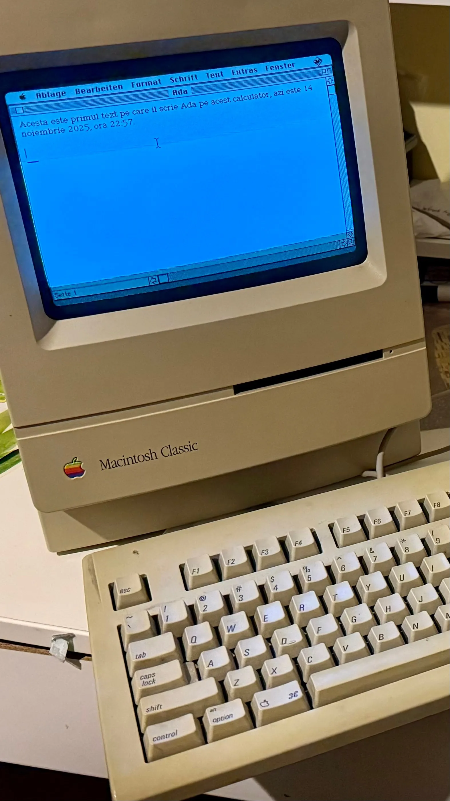 A Macintosh Classic computer with a text document open on screen
