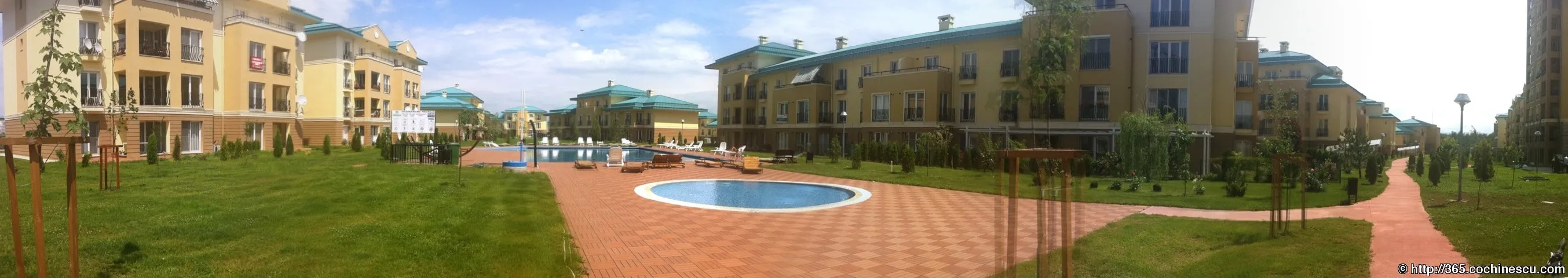 A panorama shows the garden, walkways, and swimming pools between the buildings in Cosmopolis.